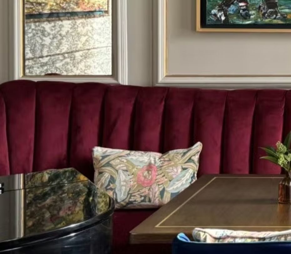 Channel-tufted burgundy velvet banquette upholstered for a Dublin hotel bar